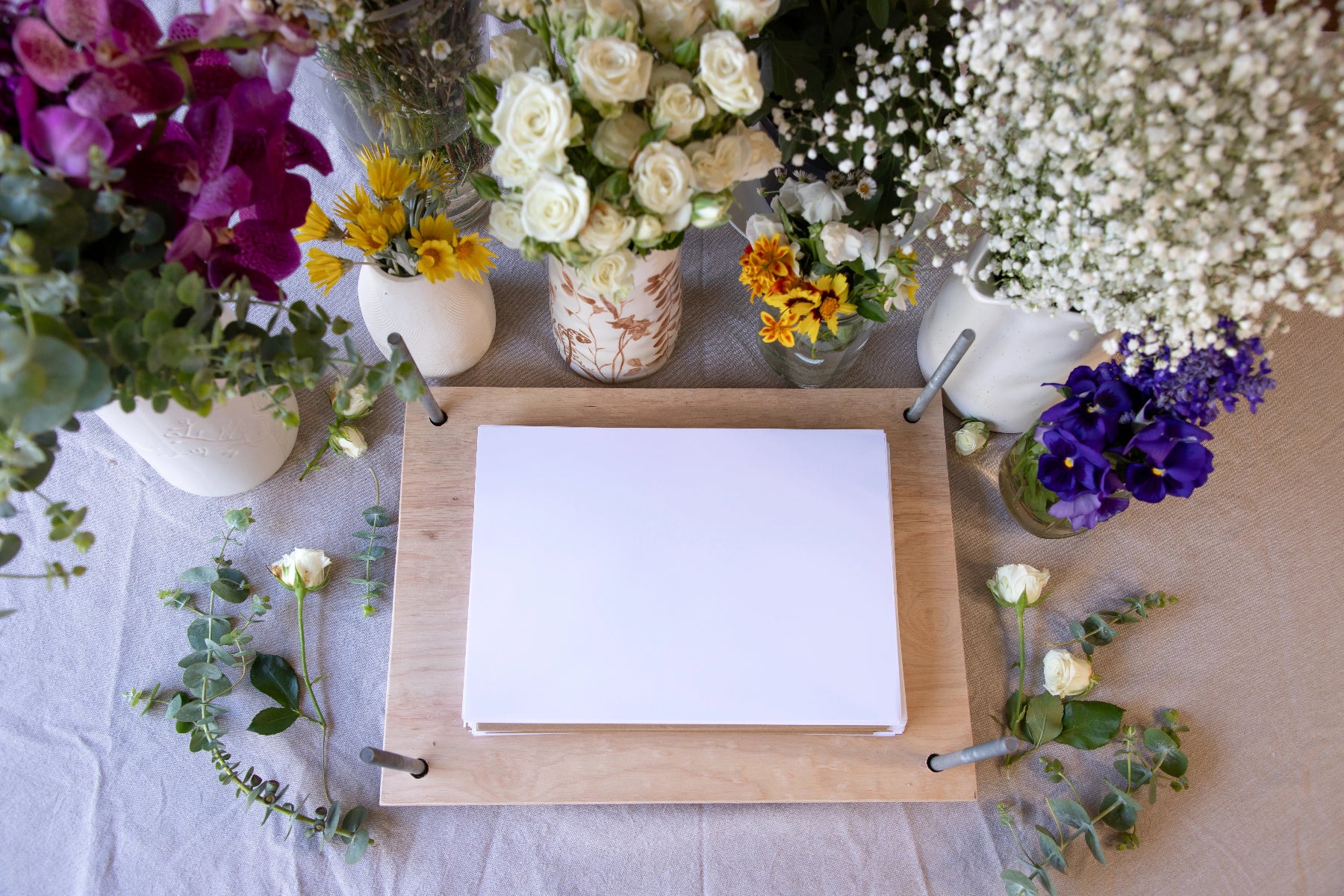 Floral arrangements on a table with a flower press in the center